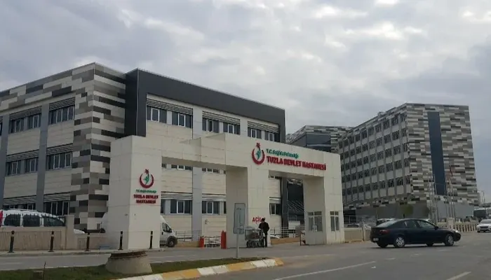 Tuzla Devlet Hastanesi'nin dış cephesi ve girişi, tabelası okunur durumda; sağda yeni blok